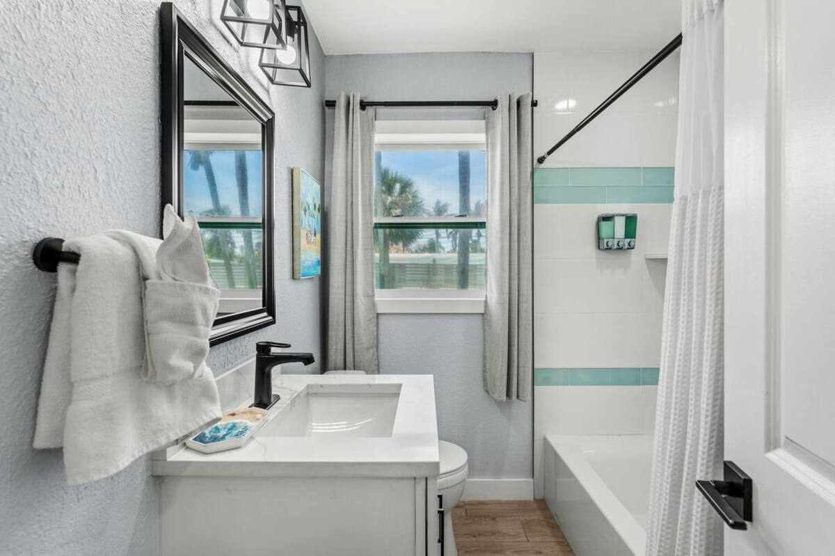 Second bathroom with shower-tub combo and coastal tile