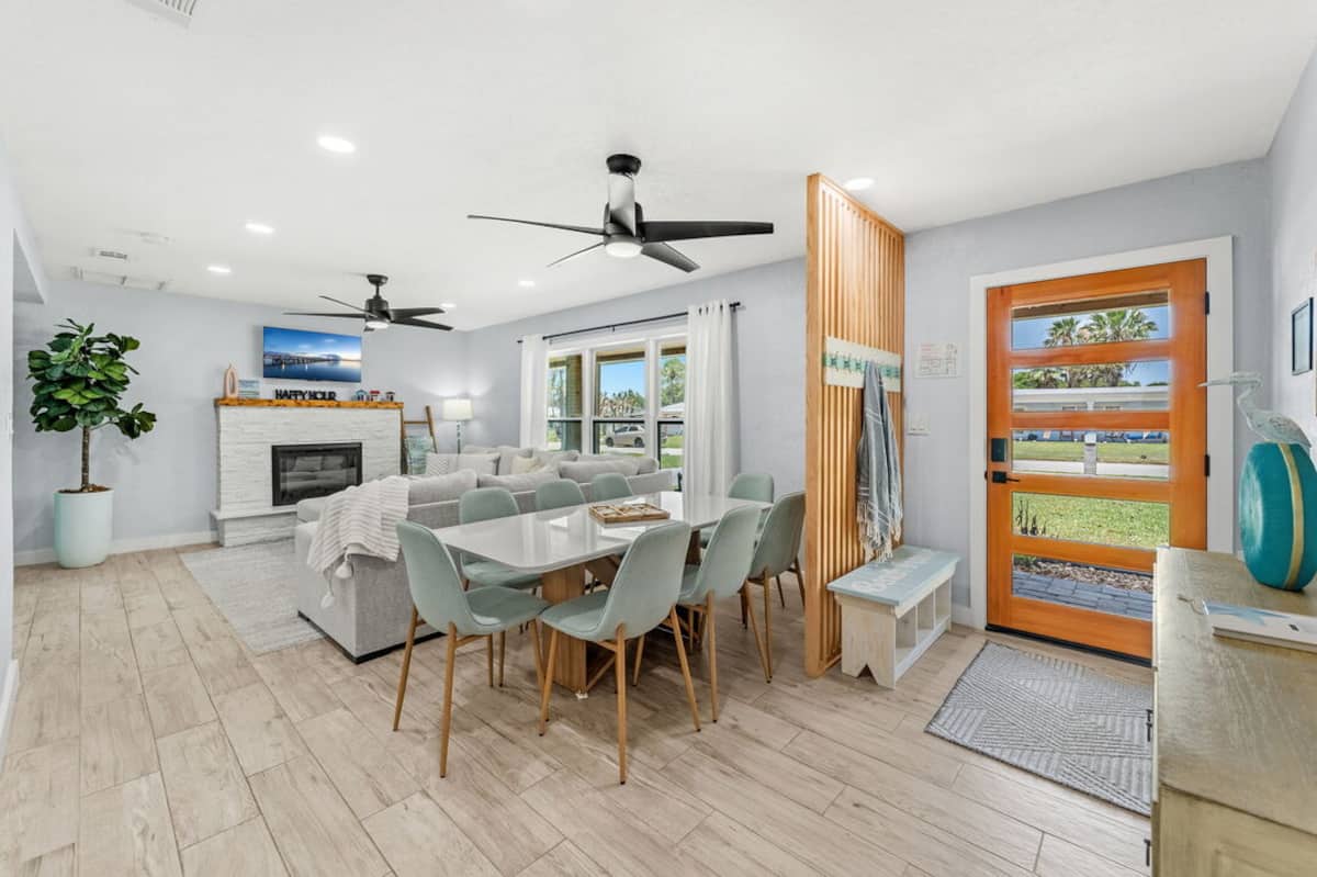 Open living and dining space with wood entry door