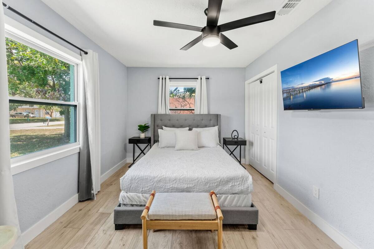 Guest bedroom with queen bed, smart TV and yard views