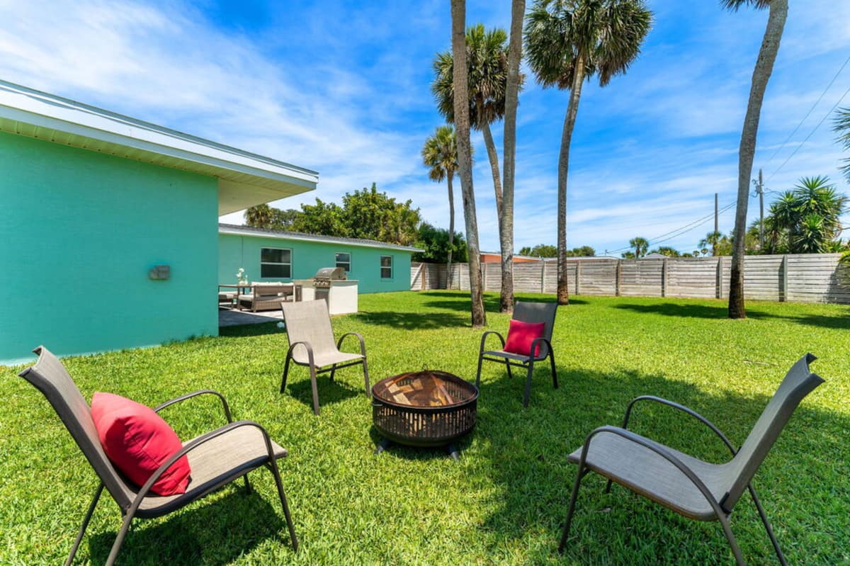 Fire pit with lounge chairs in the fenced backyard