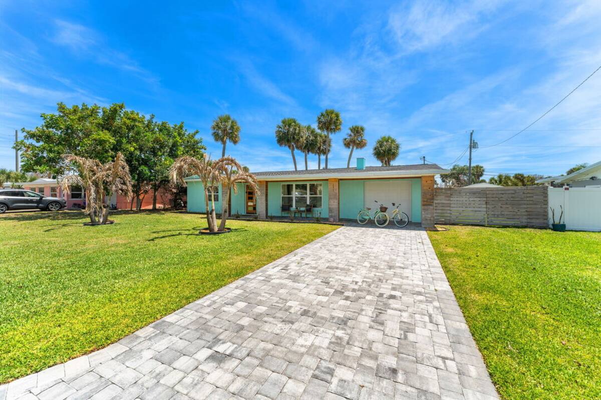 Paver walkway leading through the palm-shaded yard