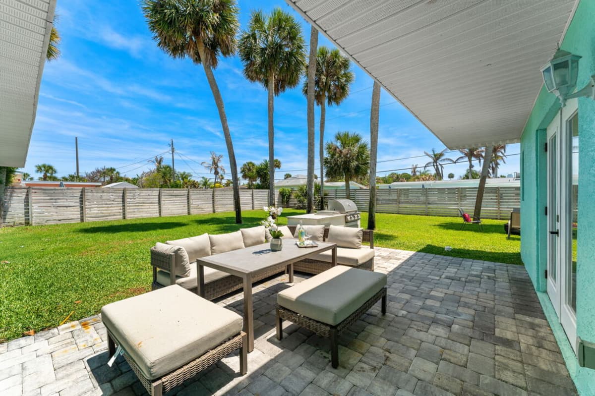 Private fenced backyard with outdoor lounge seating on a paver patio