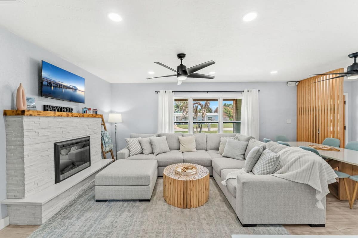 Open living room with sectional sofa, fireplace and mounted TV